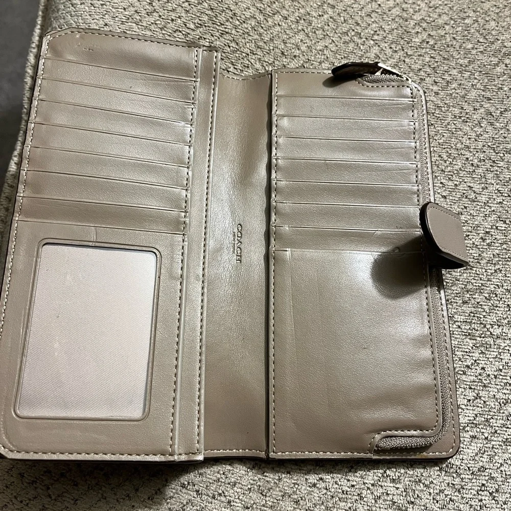 Coach wallet. Has some wear marks and wrinkles on outside of wallet.